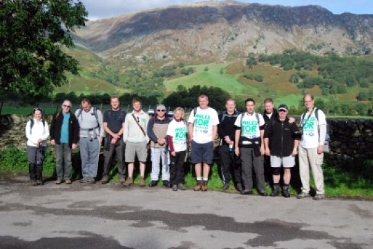 Concept staff in front a big hill on their Macmillan sponsored walk