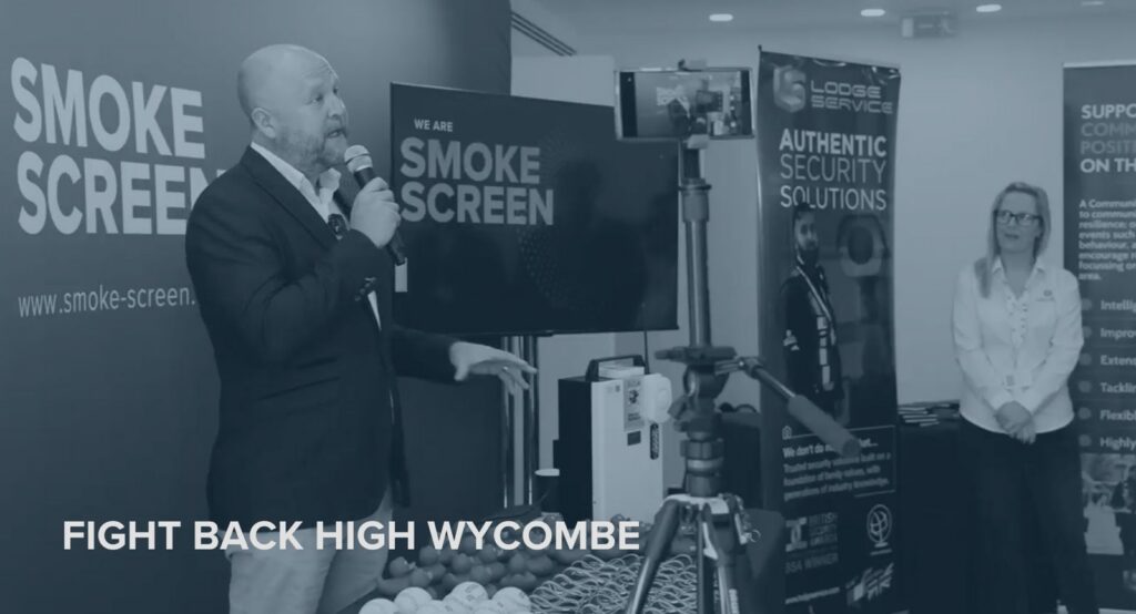 Matt Gilmartin presenting at Fight Back High Wycombe — "We Are Smoke Screen" backdrop, Lodge Service stand visible