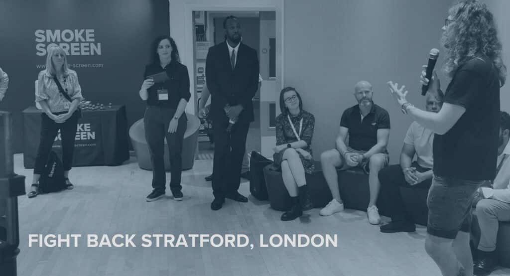 Fight Back Stratford London event — retailers and security professionals listening to a presentation, Smoke Screen stand visible in the background